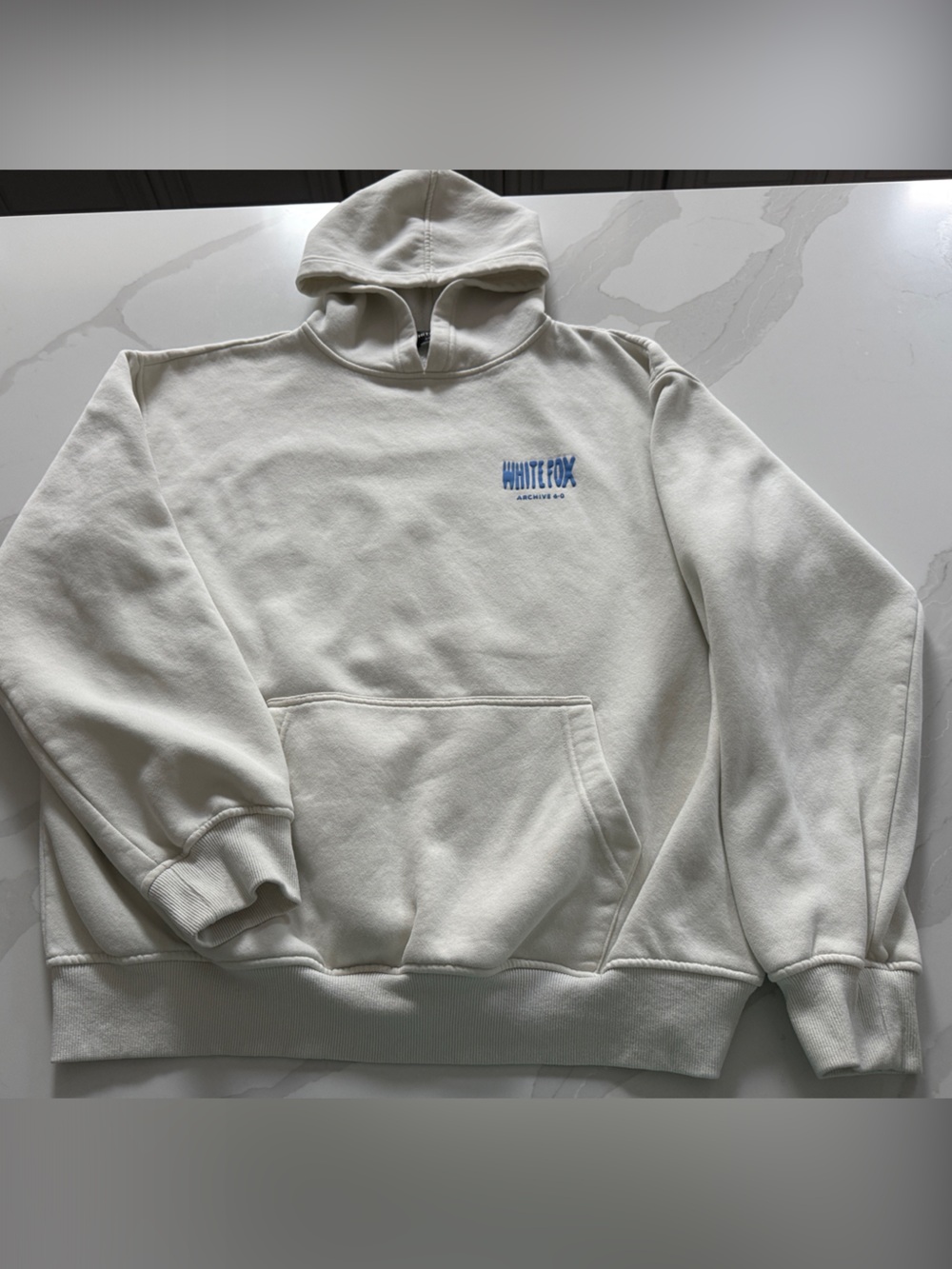White Fox Boutique Cream Hoodie with Small Blue Logo